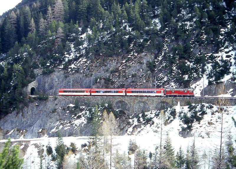 RhB Schnellzug WINTER-PANORAMIC-EXPRESS 101 von Davos-Platz ber Albula nach St.Moritz am 03.03.1998 zwischen Fuegna-Tunnel und Albula-Viadukt I mit E-Lok Ge 4/4II 614 - 2 FO PS - FO AS 4121ff. Hinweis: dieser Zug verkehrte als 2.Klasse nur am 29.12.-31.12.1997 und jeweils Dienstag bis Donnerstag vom 20.01.-12.03.1998. Blick vom Wanderweg, der im Winter aber nicht begehbar ist, Zugang nur ber Schlittel-Strae Preda - Bergn!