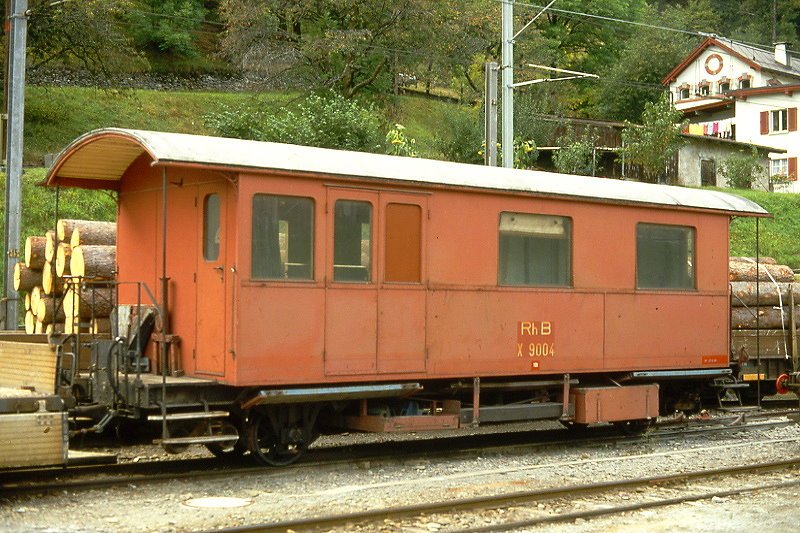 RhB - X 9004 am 02.10.1990 in Poschiavo - Hilfswagen Poschiavo - 2-achsig mit 2 offenen Plattformen - Baujahr 1914 - SWS - Gewicht 11,00t - Zuladung 0,00t - LP 10,20m - zulssige Geschwindigkeit 60 km/h - 2=27.06.1990 - Lebenslauf: ex Krankentransportwagen ChA Dk 61 - 1942 RhB Dk 3503 - 1960 X 9004 - 1995/2000 Abbruch.
