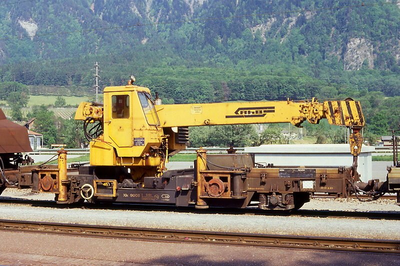 RhB - Xk 9008 am 31.05.1991 in Untervaz - Kranwagen - 2-achsig mit 1 offenen Plattformen - Baujahr 1974 - Stadler - Gewicht 20,63t - Zuladung 0,60t - LP 9,40m - zulssige Geschwindigkeit 70 km/h - 2=17.02.1987. Hinweis: Logo RhB in schwarz
