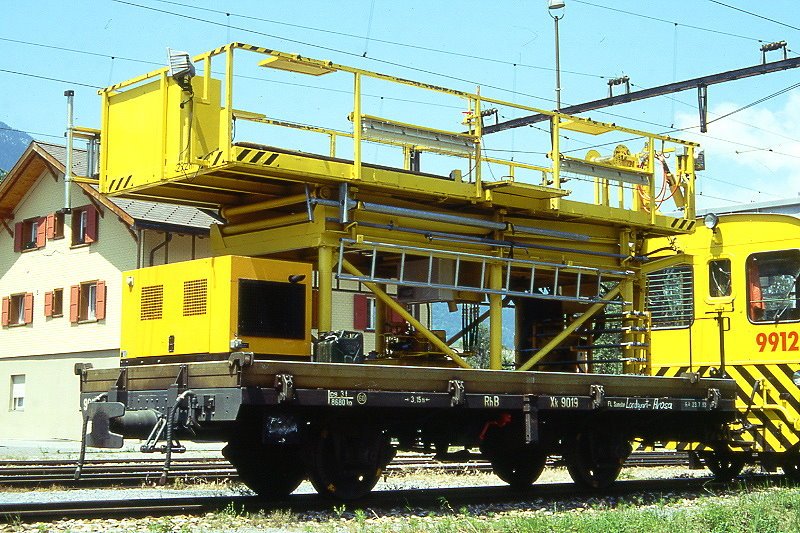 RhB - Xk 9019 II am 26.06.1995 in Untervaz - Hebebhnenwagen hydraulisch - 2-achsig mit 1 offenen Plattform - Baujahr 1903 - MAN - Gewicht 8,68t - Ladegewicht 3,00t - LP 7,50m - zulssige Geschwindigkeit Aufkleber 60 km/h - 2=23.07.1993  - Lebenslauf: ex M 1181- 1911 M 7051 - 1969 Kkl 7051 - 1978 X 9019 II - 1989 Xk 9019 II.
