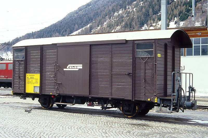RhB - Xk 9028 V am 17.03.2000 in Zernez - Materialwagen - 2-achsig mit 1 offenen Plattform - Baujahr 1913 - Reich - Gewicht 6,92t - Ladegewicht 12,00t - LP 8,49 m - zulssige Geschwindigkeit 80 km/h - 2=02.11.1998 - Lebenslauf: ex K1 5603 - 1969 Gbk-v 5603 - 12/1998 Xk 9028 V.
