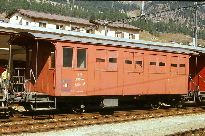 RhB - Xk 9034 am 23.09.1989 in Samedan - Montagewagen - 2-achsig mit 2 offenen Plattformen - Baujahr 1889 - SIG - Gewicht 8,00t - Ladegewicht 2,00t - LP 9,50 m - zulssige Geschwindigkeit 55 km/h - =10.12.1978 - Lebenslauf: ex LD C 32 - 1895 RhB C 52 - 1899 C 212 - 1911 C 2012 - 1940 X 9034 - 1984 remisiert - 20.03.1999 Club1889 C 2012 - 2006 WN 9801.
