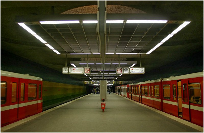 Röthenbach, Linie U2 (1986) - 

Die Bahnsteighalle des südlichen Endbahnhofes der U2 wird über Glaskuppeln zusätzlich mit Tageslicht beleuchtet. Der breite Bahnsteig kommt ohne Mittelstützen aus. Die Zugänge wurde wieder räumlich sehr offen ausgeführt. Am Südzugang führt eine lange Rampe zum Zwischengeschoß, am Nordzugang befindet sich oberirdische eine große Umsteigeanlage zu den weiterführenden Bussen.

04.03.2006 (M)
