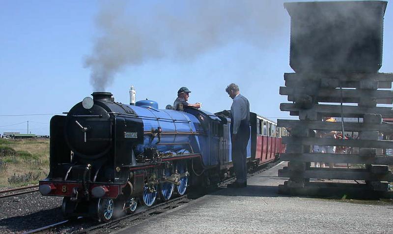 Romney, Hythe & Dymchurch Railway
Endstation Dungeness. Die Spitze des Leuchtturms ist hinter Lok Hurricane zu sehen. Als Wasserturm dient eine Wanne auf dem Schwellenstapel. (20.07.2001)