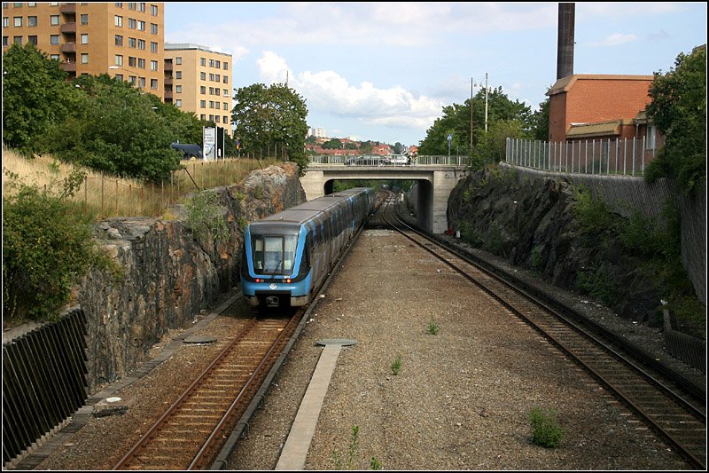 Rote Linie nach Norsborg. 

Der Abschnitt Örnsberg - Axelsberg verläuft einschließlich der beiden Stationen oberirdisch. Hier ein Blick von Axelsberg auf die Strecke in Richtung Innenstadt.
Eröffnet wurde der Abschnitt Örnsberg - Sätra mit vier Stationen am 16.5.1965. 

20.08.2008 (M)