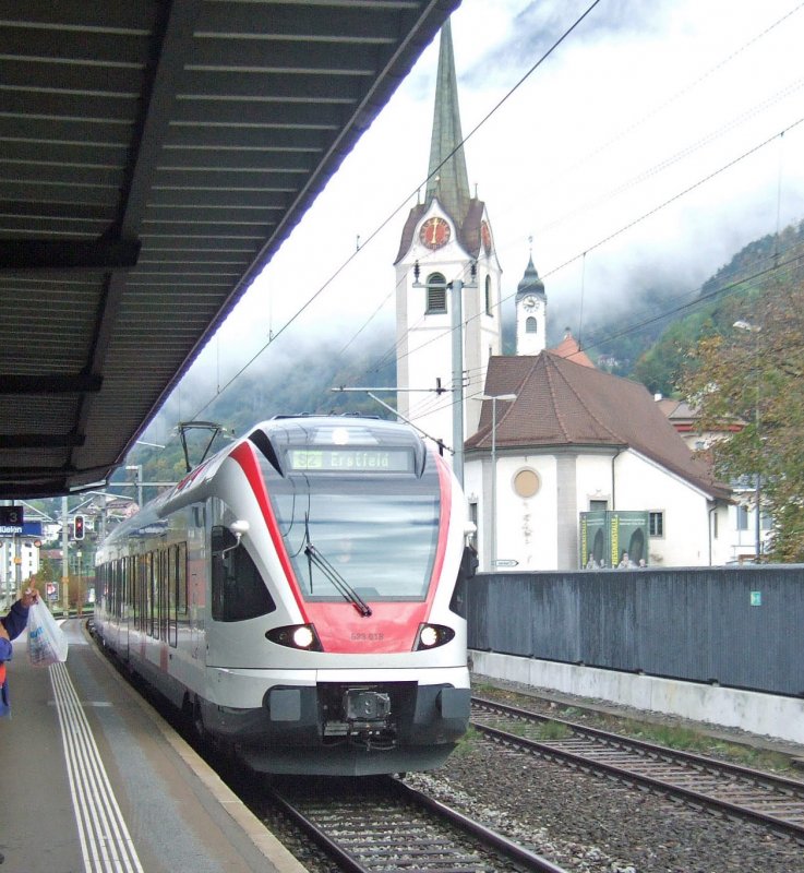 rund und spitzig: Seit die NPZ weitgehend in Flelen verschwunden sind, ist die Kirche dort wieder das eckig- und spitzigste Element beim Bahnhof Flelen. Am 09.10.09 begegnet sie dem RABe 523 018.