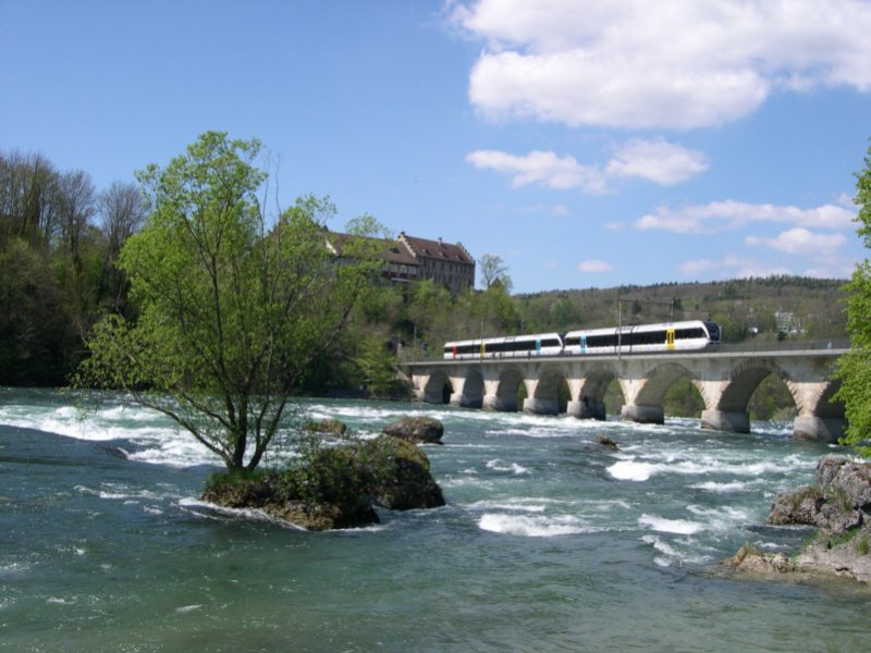 Rund um den Rheinfall 2008 - Reist man von Schaffhausen nach Winterthur berquert man auf dieser Brcke den Rhein direkt am Rheinfall. Links oben trohnt das Schloss Laufen und direkt nach dem linken Tunnel befindet sich die gleichnamige Haltestelle. Von hier aus ist es nur ein Katzensprung zum Rheinfall. Die beiden GTW´s der Thurbo sind am 28.04.2008 als S33 Winterthur-Schaffhausen unterwegs. Nchster Halt: Neuhausen am Rheinfall.