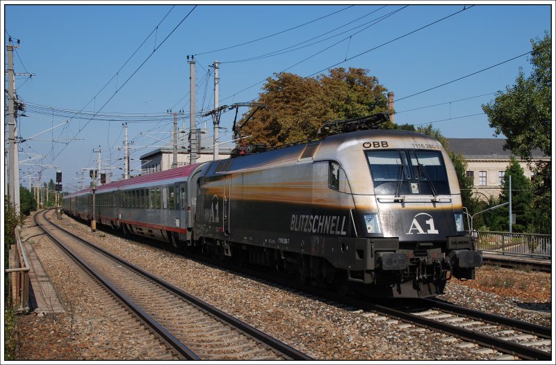 Rund zwei Wochen wird 1116 280 noch im A1 Design auf �sterreichs Schienen unterwegs sein, dann wird auch sie ihre Folien verlieren. Am 26.9.2009 bespannte sie den OIC 535  K�RNTEN wasser.reich  von Wien nach Lienz in Osttirol. Die Aufnahme entstand bei der Durchfahrt der S-Bahn Station Wien Atzgersdorf mit dem ehemaligen Bahnhofsgeb�ude von Atzgersdorf-Mauer im Hintergrund.