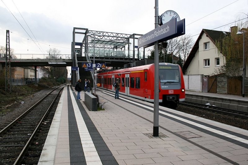 S-Bahnhof HD-Kirchheim/Rohrbach: Einfahrender S-Bahnzug der Linie von Karlsruhe ber HD bis Mannheim. Dieser Bahnhof bedient den Sden Heidelbergs mit der Nord-Sd Linie. Erst 2004 fertiggestellt sind die Bahnhfe alle sehr modern und mit Aufzuegen ausgestattet, auch die Busanbindung ist gut, allerdings knnten Zuege und Busse hufiger fahren, da oft berfllt. 