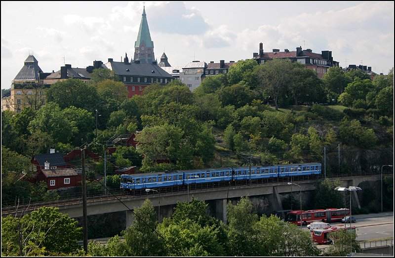 Saltsjöbanan, Folkungsgatan - 

Hier überquert die Bahn ein zweites Mal die Folkungsgatan. Rechts im Hangbereich soll eine Haltestelle für die Saltsjö- und die Tvärbanan entstehen. Ursprüngliche Pläne sahen hier eine weitgehend unterirdische Führung der Strecke vor, mit einer offenen Station im Bereich Tegelviksplan vor dem Fährhafen. 

24.08.2007 (M)