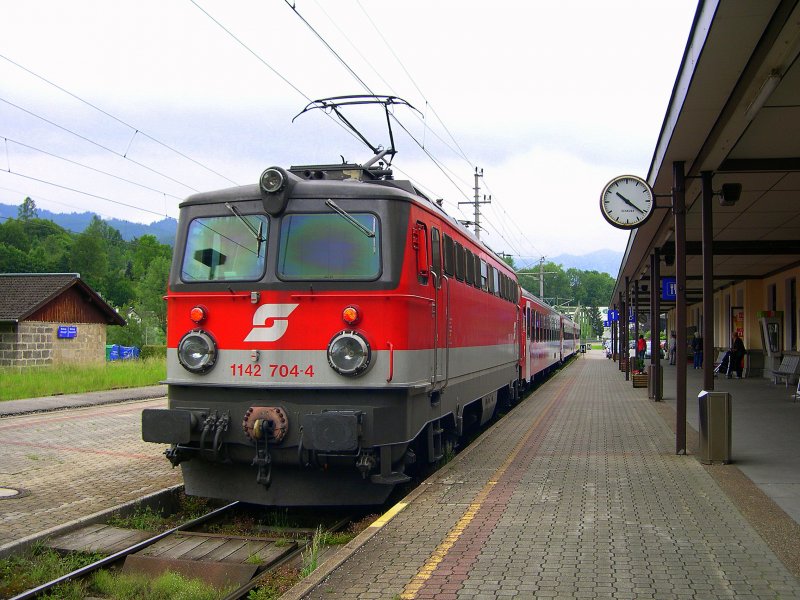 Salzkammergut 2009 - Einen City-Shuttle Pendelzug schiebt am 28.05.2009 die 1142 704 aus dem Bahnhof Bad Ischl. Auf der Salzkammergutbahn schieben die Loks in Richtung Obertraun. Die Baureihe 1142 ist neben 1044, 1016 und 1116 auf dieser Strecke allgegenwrtig.