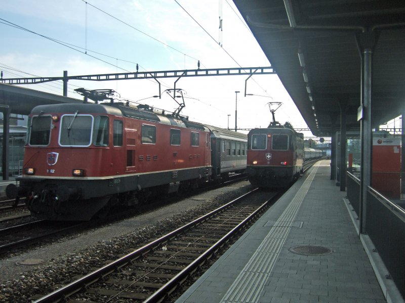 SBB (-Cargo): Der Interregio Basel-Locarno durchfhrt am 15.4.09 mit der Re 4/4  11302 an der Spitze den Bahnhof Rotkreuz. Die 11322 muss auf die Fahrberechtigung nach Luzern warten, nachdem sie zwei Zement- und zwei Kieswagen von Luzern nach Rotkreuz brachte.