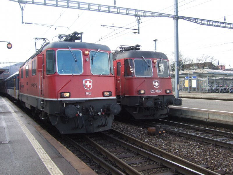 SBB (-Cargo): Re 4/4  11157 mit Regionalzug lsst den vorbeifahrenden Gterzug mit der Re 620 069 an der Spitze passieren. (Olten, 11.3.09)