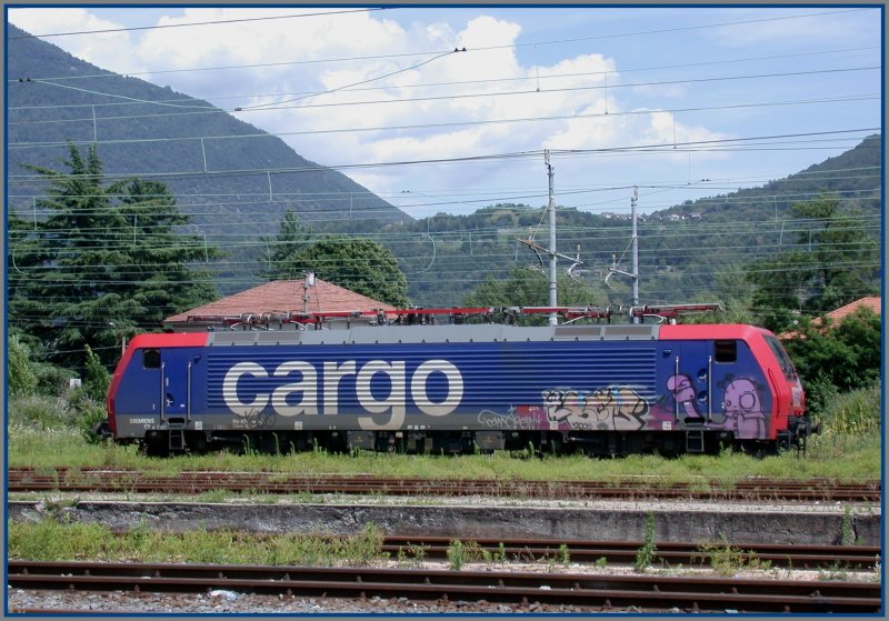 SBB Cargo Re 474 005-? bereits in einem hsslich versprayten Zustand in Domodossola. Im Hintergrund das Val Vigezzo, wo die Centovalli-Schmalspurbahn durchfhrt auf dem Weg von Domo nach Locarno. (23.06.2007)