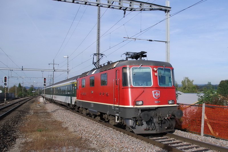 SBB Re4/4 II 11200. Einfahrt des InterRegio nach Zrich in den Bhf. Niederglatt (Zrich) am 10.10.2006. Mit einem groen Teleobjektiv kann man auch gut die landenden Flugzeuge nach Kloten vom Bahnsteig aus fotografieren.