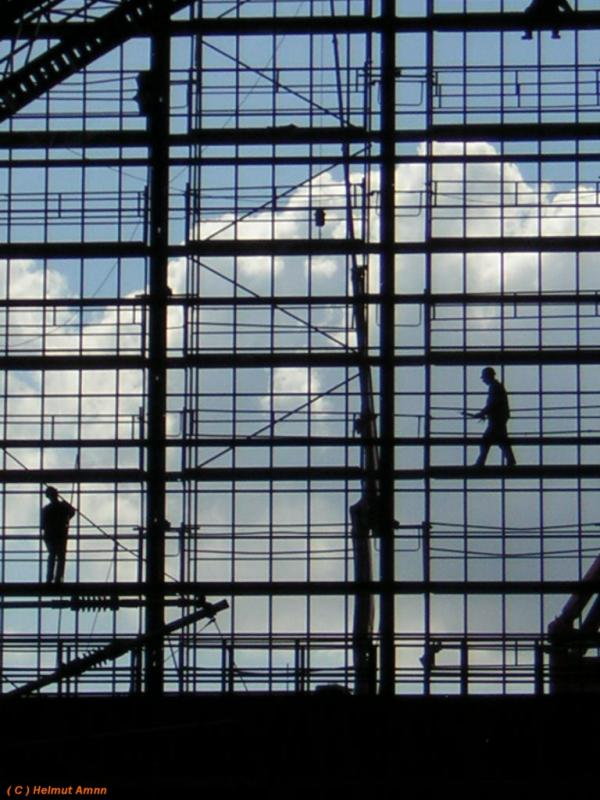 Schattenspiele........ Arbeiter im Gerst hinter der Glasfassade einer Halle des Frankfurter Hauptbahnhofes, aufgenommen am 10.05.2005, lassen die Dimension des Gebudes erahnen, die Schatten der arbeitenden Menschen wirken beinahe wie Marionetten.