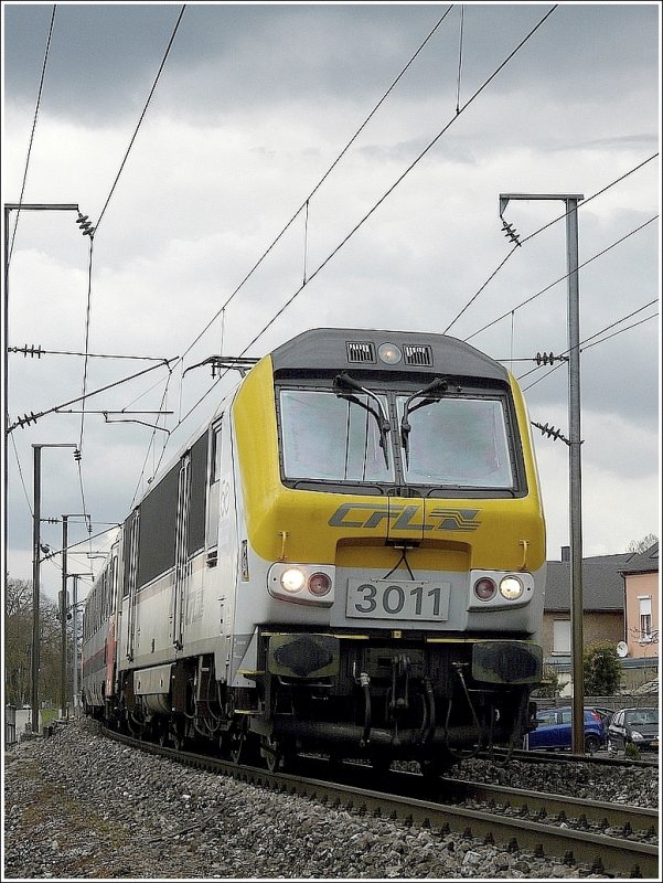 Schauerwolken verdunkeln den Himmel kurzfristig am 29.03.09 in Rollingen/Mersch, whrend der Durchfahrt der E-Lok 3011 in Richtung Luxemburg. (Jeanny)
