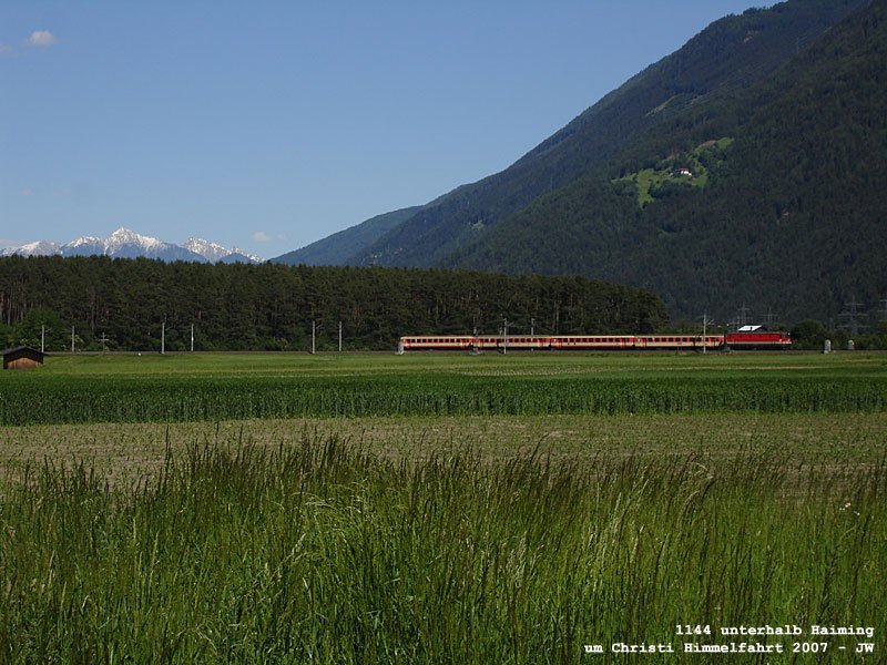 Schlierenkomposition in rot-beige mit 1144er strebt Landeck-Zams zu, im Hintergrunde leuchtet die Reither Spitze (oberhalb von Seefeld), die Felder liegen unweit von Haiming. Um Christi Himmelfahrt 2007 kHds