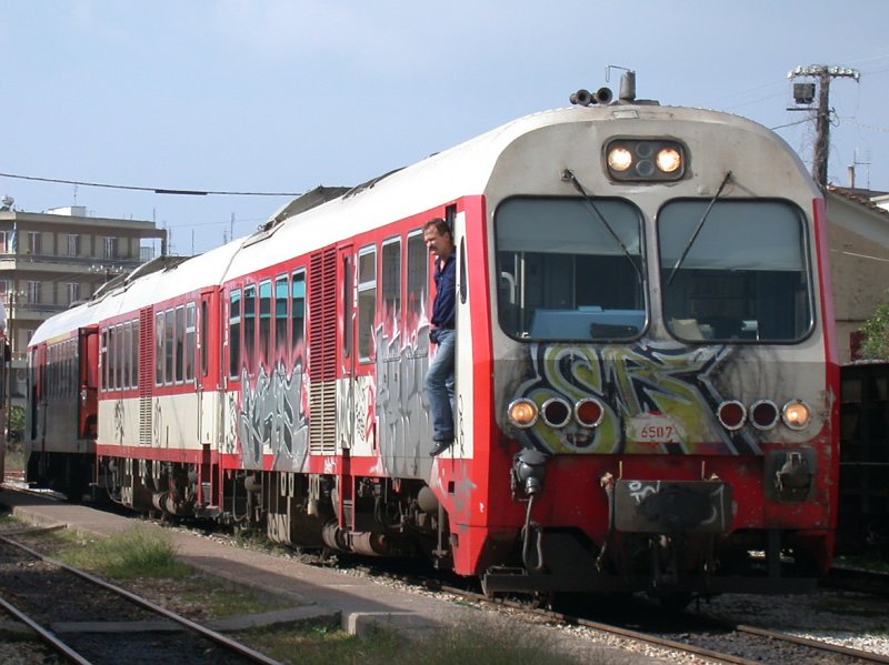Schmalspurbahnhof der OSE in Pirgos auf dem Peloponnes. Soeben ist ein dreiteiliger MAN Dieseltriebzug als IC aus Korinth via Patras eingetroffen. Leider gibt es auch in Griechenland Vandalen, die das Erscheinungsbild der Bahn verschlechtern. (30.10.2006)