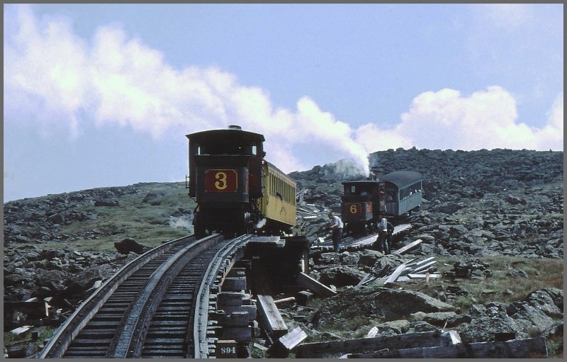 Schon ber der Waldgrenze, inmitten einer Gerllhalde, befindet sich die obere Ausweichstelle Skyline Siding. Zwei Loks mit zwei Wagen haben in dem Gleisstumpen Platz und warten auf die beiden Gegenzge. Das Umlegen einer Weiche dauert ein wenig, denn es mssen 12 Einzelteile umgestellt werden. Vllig untypisch fr die USA werden ausgewechselte Schwellen, Balken und anderes Material einfach neben dem Geleise liegengelassen, sodass man stndig das Gefhl hat, man befahre eine Entsorgungsdeponie. Lok 3  Agiocochok  (Baujahr 1883) und Lok 6  Kancamagus  (1874) in der Skyline Siding. (Archiv 02.08.1998)