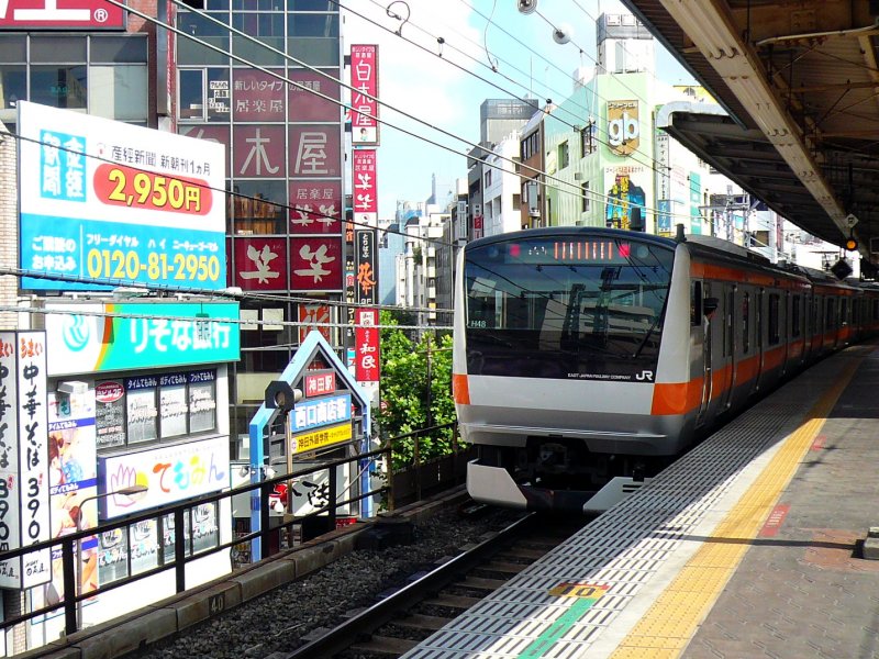 Serie 233: Ein Zug in der Innenstadt mit ihren vielen kleinen Bars und Restaurants. Steuerwagen KU-HA E233-1 verlsst gerade den Bahnhof Tokyo-Kanda, 16.August 2008. CH-LINIE 