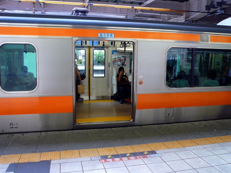 Serie 233: Wenn man an dieser Stelle wartet (Bodenmarkierung!),kann man in einen Wagen mit schwächer eingestellter Kühlung einsteigen; die Markierung findet sich auch oberhalb der Wageneingangstüre. Wagen MOHA E233-201, Tokyo-Mitaka 1.September 2008. 