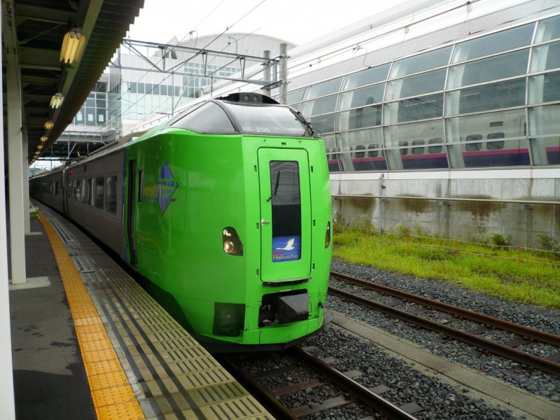 Serie 789: Die Bahn unter der Tsugaru-Meerenge. Triebwagenzug Serie 789 der JR-Hokkaidô; rechts die Endstation des Shinkansen (bis Dezember 2010) erkennbar. Die 5 6-Wagen-Züge Serie 789 (Wechselstrom) wurden 2002 erbaut, 2005 kamen 4 Wagen für Ergänzungsmodule dazu. Hier steht Steuerwagen KUHA 789-205 in Hachinohe, 24.August 2008. 