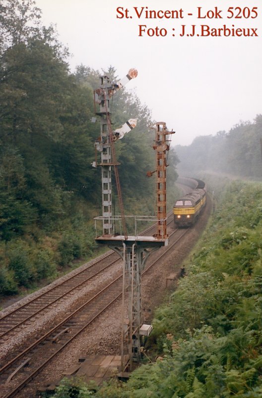SNCB - Die erste Lok ist die General Motor 5205 und die zweite ist von derselben BR. Beiden ziehen einen schweren G�terzug aus
Metz nach Bertrix und Libramont. Wir sind in Saint Vincent in September 1997, die Elektrifizierung ist noch nicht da und der
alte Signal funktioniert noch. Foto : J.J. Barbieux