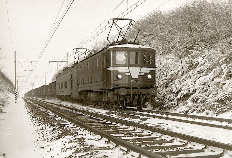 SNCB - In der nhe von Lillois, die 101.016 (spter BR 29), zusammen mit einer BR 123 (spter 23) zieht einen langen Gterzug, warscheinlich nach Antwerpen. Die Loks BR 101 waren die erste elektrische Loks bei der SNCB : 20 St. von ACEC und La Brugeoise (jetzt Bombardier)in 1949-50 geliefert. Winter 1966. Foto : J.J. Barbieux. 