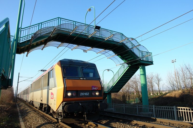 SNCF 26162. Sehr dicht rauscht der Schnellzug mit hoher Geschwindigkeit an mir vorbei. Der Luftzug reisst mir die Mtze vom Kopf. brigens, diese schne Fugngerbrcke habe ich diesmal ganz im Bild, im Oktober 2006 habe ich leider nicht so darauf geachtet. Bartenheim im Elsass am 2.2.2007.