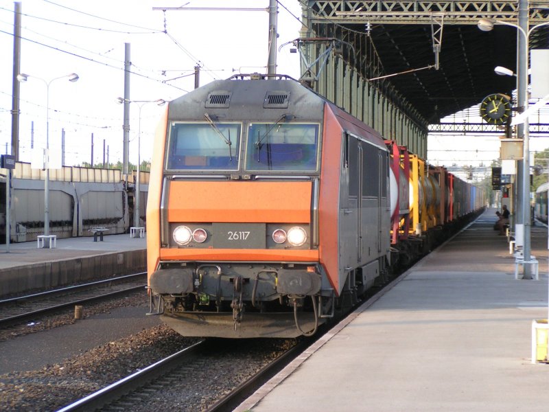 SNCF Elok des Typs Sybic mit der Nummer 26117 mit gemischtem Gterzug bei der Durchfahrt durch die Bahnsteighalle von Narbonne (Sdfrankreich) am 11.08.2004.