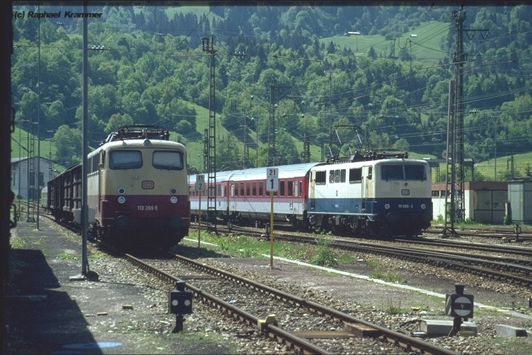 So ungerecht kann die Welt sein: Whrend 111 059-2 mit einem EC aus Richtung Innsbruck vorbeirauscht, steht der einstige Stolz der DB, die 113 269-5, noch in TEE-Lackierung mit vier Gterwgen abseits. Aufgenommen Anfang der 90er in Garmisch-Partenkirchen.