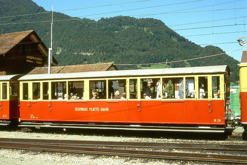 SPB - B 28 am 20.06.1995 in Wilderswil - 2.Klasse Personenwagen 4-achsig - Baujahr 1906 - vRoll/R&J - Gewicht 6,40t - Sitzpltze 42 - LP 10,69m - zulssige Geschwindigkeit 25 km/h - =08.05.1991 - Lebenslauf: ex WAB C4 72 - ? B4 79 - 1963 SPB B 28 - 2002 B 52 neuer Kasten.
