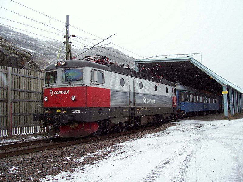 SSRT Rc6 1328 mit Regionalzug nach Lulea fhrt am 09.10.2006 in der ersten schwedischen Haltestelle Riksgrnsen an, die Haltestelle befindet sich innerhalb der Schneeschutzgalerie. Die 40 km lange norwegische Strecke heit Ofotbanen, benannt nach dem Gebirge, durch das sie fhrt, die schwedische Strecke bis Lulea heit Malmbanan (Erzbahn).