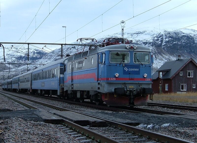 SSRT Rc6 1329 noch in alter SJ-Lackierung mit Nachtzug Stockholm - Narvik am 07.10.2006 in Vassijaure. Der Zug mute hier fast eine Stunde auf den Gegenzug Narvik - Lulea warten, die Begegnung sollte in der Ausweichstelle Kopparasen stattfinden, da Vassijaure nur einen Bahnsteig hat, Ausstieg auf das Schotterbett.