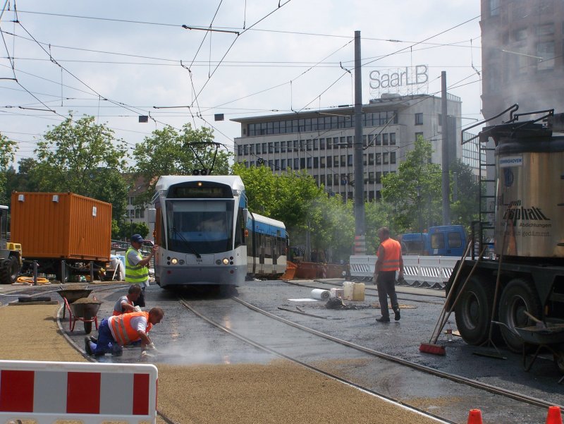 Stadtbahnwagen 1026 der Saarbahn durchfhrt auf dem Weg Richtung Riegelsberg Sd die Baustelle am Saarbrcker Hauptbahnhof, wo derzeit der komplette Bodenbelag erneuert wird, und durchquert dabei den Rauch des frisch verlegten Asphalts (28.07.2008).