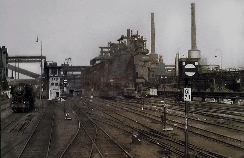 Stadtteil Hagen-Haspe, mit dem Werksbahnhof der Klckner-Htte.
Ganz links verluft die ehemalige Talbahn  n. Ennepetal, rechts
hinter den Hochfen, die Haupstrecke Hagen Hbf- Wuppertal-Kln.
Im Bild links die 50 098 vom Bw Hagen Gbf
Keine besondere Qualitt der Aufnahme. Das Negativ stammt v. 1964! 