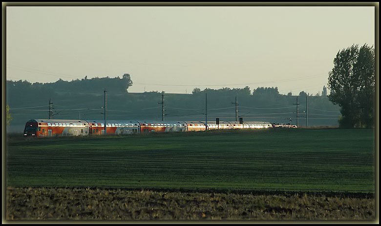 Stimmungsvoll spiegelte sich die untergehende Sonne am 22.9.2006 in dieser Doppelstockgarnitur welche von einer 1116 geschoben wurde. Die Aufnahme entstand kurz vor Zellerndorf im Wienviertel in Niedersterreich.