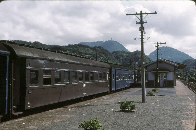 SU-HA 42 - Altbau-Personenwagen: Serie SU-HA 42 (スハ42)ist eine verbesserte Version der etwas leichteren, klassischen O-HA 35 (オハ35); 140 Wagen 1948-1950 gebaut. Hier ein zu Staatsbahnzeiten typischer Zug der San-In-Linie (San-In =  Berg-Schatten , d.h. Schattenseite/kalte Seite des Westteils der japanischen Hauptinsel); SU-HA 42 58 (スハ42 58) in Nima, 8.September 1983. (SU ス=schwere Wagen 37,5-42,5 Tonnen, HA ハ= gewöhnlicher Sitzwagen) 