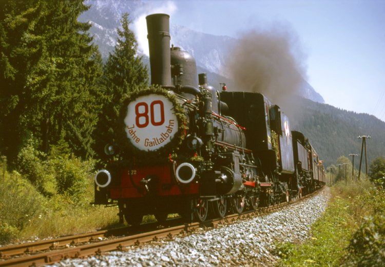 Sdbahnlok 17 c - auch bekannt als 372 GKB - mit einem Sonderzug zum 80 - jhrigem Streckenjubilum der Gailtalbahn Arnoldstein - Krtschach - Mauthen im August 1974 bei Ntsch. Im Hintergrund der Dobratsch.