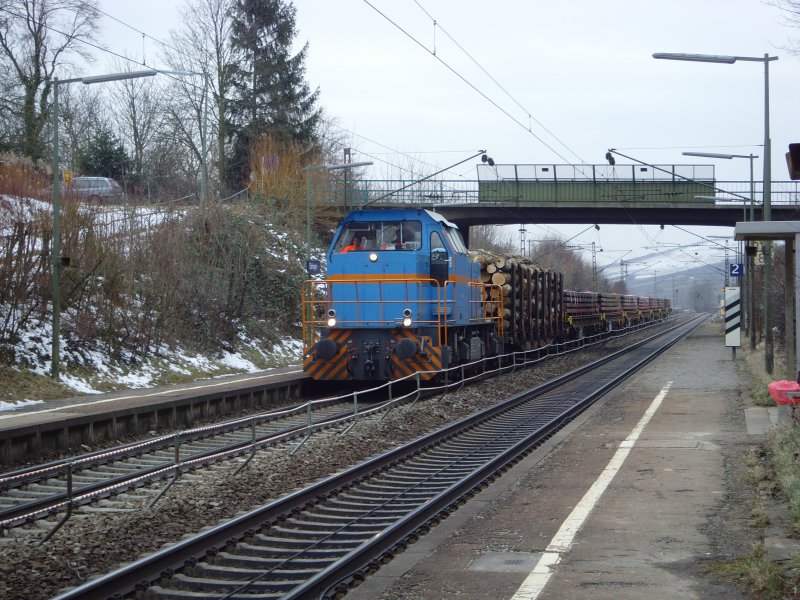 SWEG V103 kam mit einem Langholzwagen und sieben mit Holzschwellen beladenen Flachwagen durch den Haltepunkt Ebringen. 20.02.09
