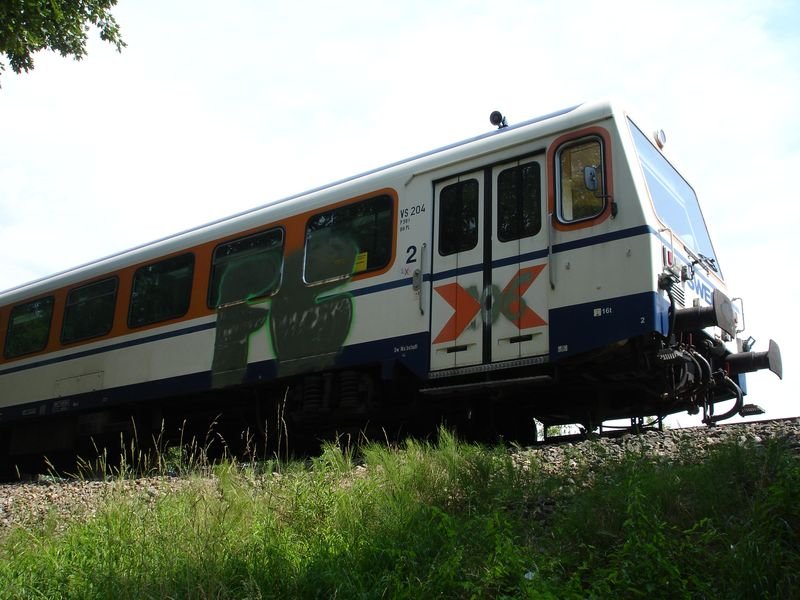 SWEG VS204 am 05.07.06 in Neckarbischofsheim Nord.
Die rechte Seite des Steuerwagens am Führerstand, fiel scheinbar
vor wenigen Tagen Graffitispryern zum Opfer.
