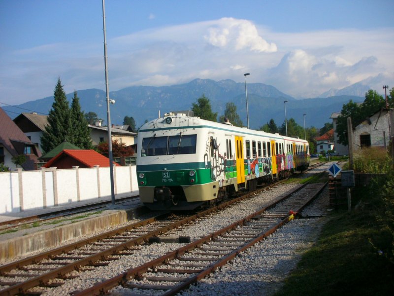 SZ 713 124 + 715 124 als Zug 3171 in Kamnik Graben am 8.8.08.
Durch das sehr  eigenwillige  Design ist kaum erkennbar, dass der Steuerwagen in rot-orange-gelb lackiert ist. Es handelt sich um den umgezeichneten ehemaligen 715 109, wie aus der Nummer im Inneren des Wagens hervorgeht.
