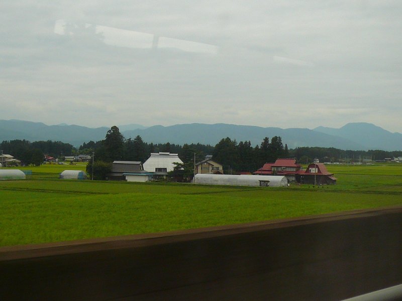 Tôhoku-Shinkansen. Ausser an den Bahnhöfen ist es praktisch nicht möglich, Shinkansen-Züge in ihrer Landschaft aufzunehmen, weil ihre Strecken auf  Stelzen  gebaut sind und Lärm- und Schneeschutzwände die Züge von aussen her ohnehin fast unsichtbar machen. Deshalb hier einige Bilder aus dem rasenden Zug.Im Raum Hanamaki, südlich von Morioka, 23.August 2008. 