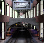 Spiegel und Betonbögen über den Bahnsteiggleisen -    Blick von einer Zwischenebene hinunter auf die mittleren der vier Durchgangsgleise in der unteren Bahnsteigebene.