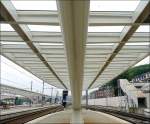 Das berdach eines Bahnsteiges im Bahnhof Lige Guillemins fotografiert am 18.05.08. Rechts im Bild sieht man die provisorische Fugngerbrcke zum Stadtteil  Colline de Cointe . Wenn der Durchgang unter den Gleisen fertiggestellt ist, verschwindet diese Brcke wieder. Die beiden Stadtteile  Colline de Cointe  und  Quartier des Guillemins  werden spter durch den neuen Bahnhof verbunden, nachdem sie 170 Jahre durch den alten Bahnhof getrennt waren. Der Name  Guillemins  stammt brigens von einem Kloster aus dem Mittelalter, welches  St Guillaume  gewidmet war und in diesem Stadtteil stand. Die Mnche wurden  Guillemins  genannt und spter wurde dieser Name fr den ganzen Stadtteil bernommen.