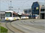 Ein Straenbahnwagen des Kusttram verlt am 12.04.09 die Haltestelle Oostende Station in Richtung De Panne vor der Kulisse der Fhre nach England, welche im Hafen von Oostende liegt.