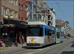 Die Tram N 6015 von de Kusttram bahnt sich am 10.07.10 ihren Weg durch die engen, blumengeschmckten Straen von De Panne. (Jeanny)