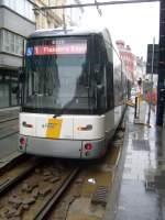 Hier drckt sich gerade eine Strassenbahn der Linie 1 von DeLijn nach Flandres Expo eine Strassenschranke in Gent auf.