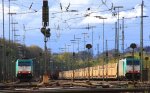 Die Cobra 2824 steht mit einem Containerzug und die Cobra 2815 steht mit einem Autoleerzug und warten auf die Abfahrt  nach Belgien bei Aprilwetter mit Sonne und Wolken.